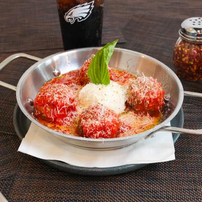 Meatballs in tomato sauce, with ricotta cheese and basil.