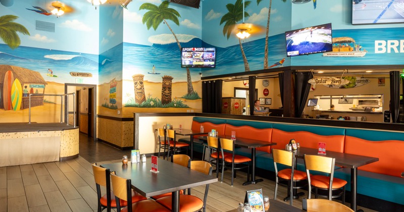 Beach-themed restaurant interior with tropical murals and casual dining setup.