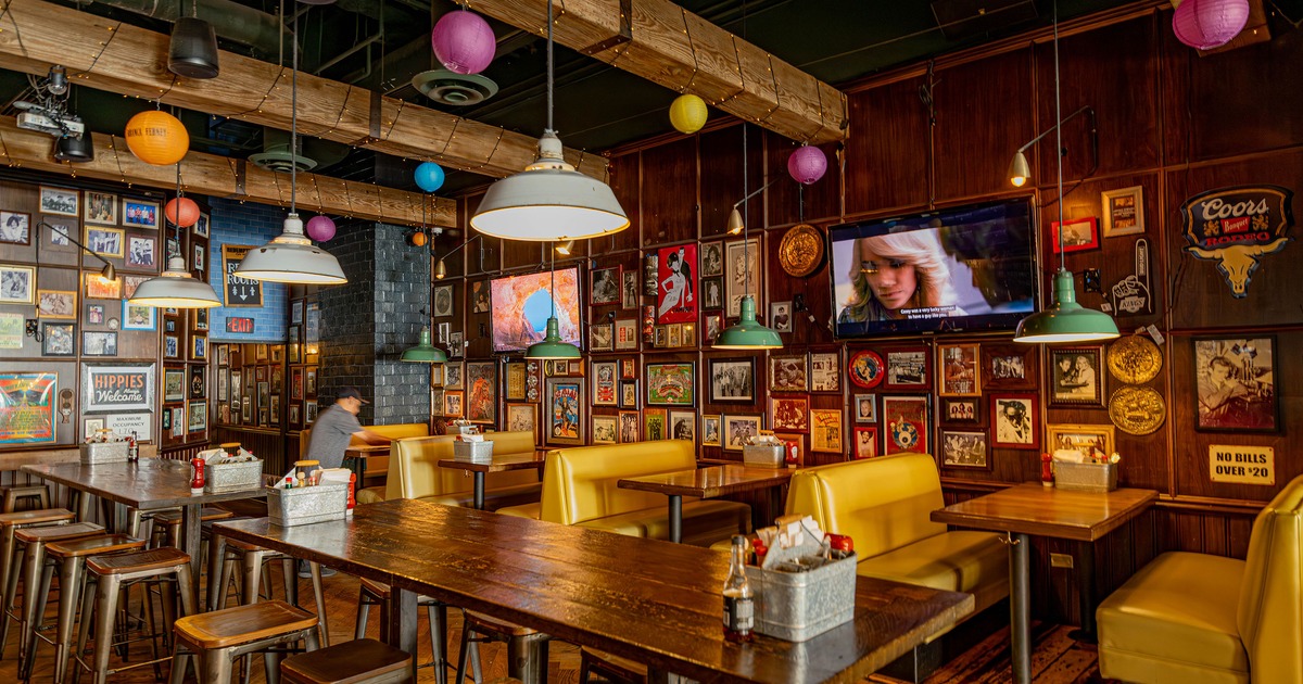 Spacious and cozy interior seating area with upholstered booths, high tables and stools