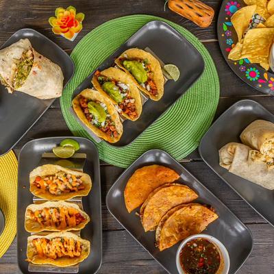 Assorted tacos and burritos arranged on a table.