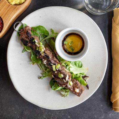 Grilled Beef Tenderloin served over greens, served with soy sauce marinated egg yolk.