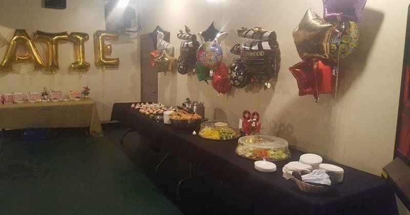 Wide view of the pub with guests sitting at the bar counter and the seating area