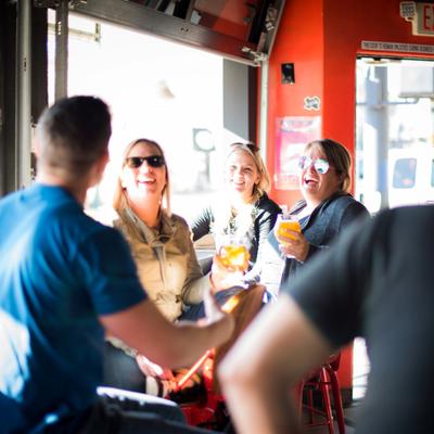 People in a bar with drinks laughing.