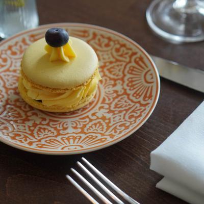Yellow Macaroon topped with a blueberry.