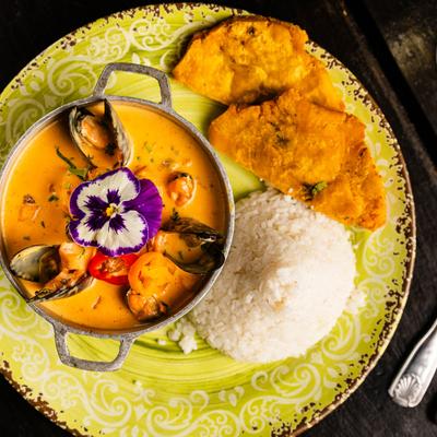 Seafood soup, rice, and fried plantains.