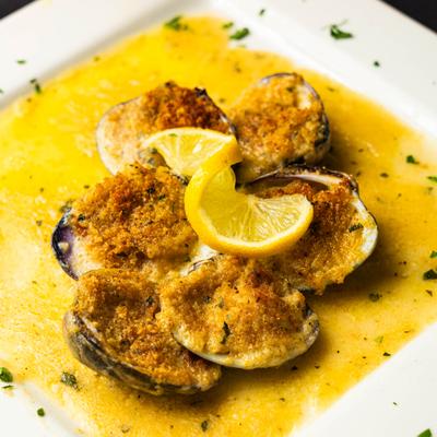Baked clams topped with seasoned breadcrumbs and a slice of lemon.