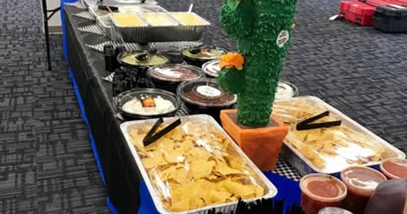 Buffet table set up with Mexican-style catering, featuring trays of food