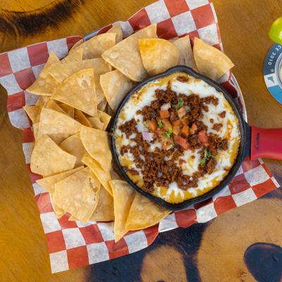 Borracha Queso Dip topped with mozzarella and salsa fresca, served with tortilla chips.