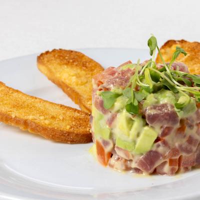 Tuna tartare with avocados, tomatoes, mustard - lemon sauce, microgreens and crostini.
