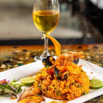Seafood Paella served with a glass of white wine.