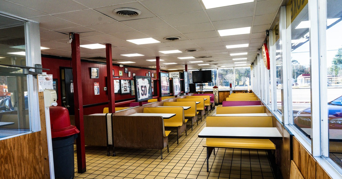Interior, dining area, small seating booths with tables, large windows, tile flooring