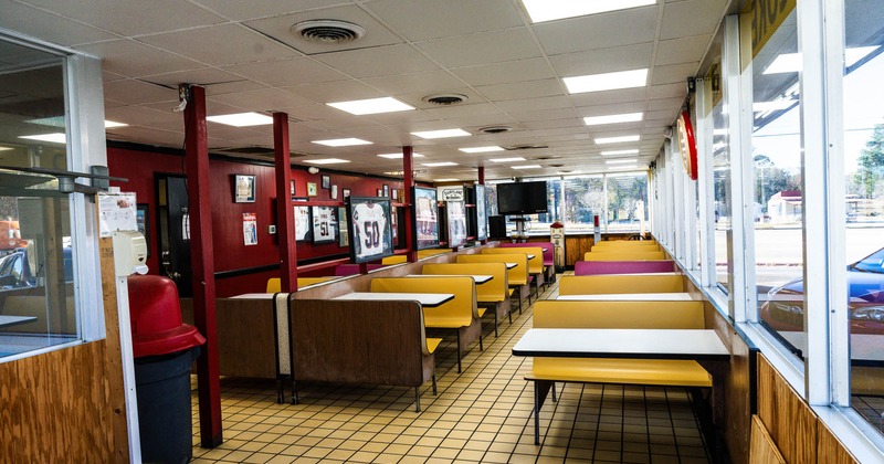 Interior, dining area, small seating booths with tables, large windows, tile flooring