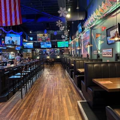 Interior with both booth and counter seating, TV screens and decorations.