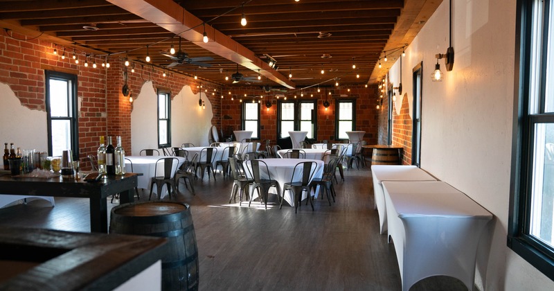 An event room with brick walls and tables set for a gathering