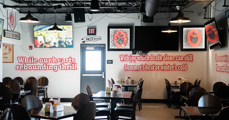 Interior, dining area, back exit, tables for four and six people, carpet flooring, TV on the wall