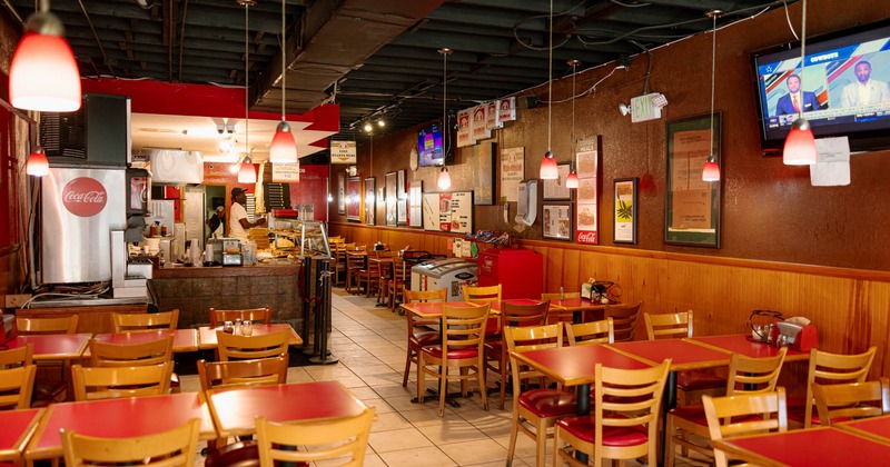 Interior, dining area, tables and chairs ready for guests, posters and pictures on the wall