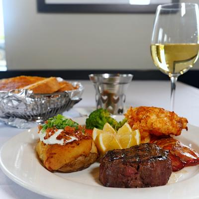Surf and Turf, with Filet Mignon, lobster, baked potato, and veggies.