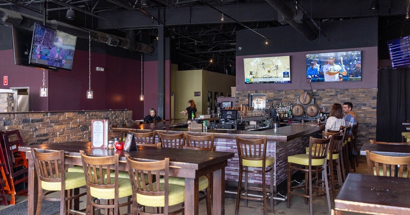 Interior, wooden tables and stools with bar in the back