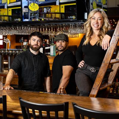 Bar staff posing behind the bar.