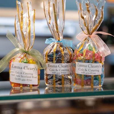 Three gift bags from Emma Cleary's Cafe & Catering displayed on a glass shelf.