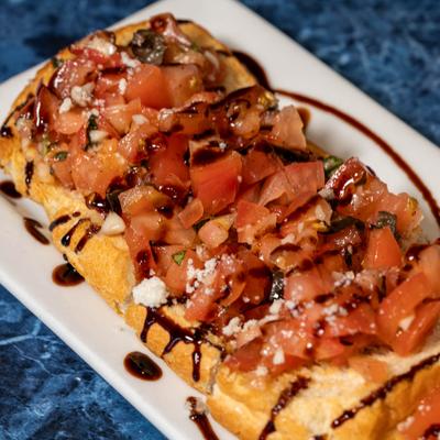 Tomato Bruschetta topped with balsamic glaze drizzle, close-up.