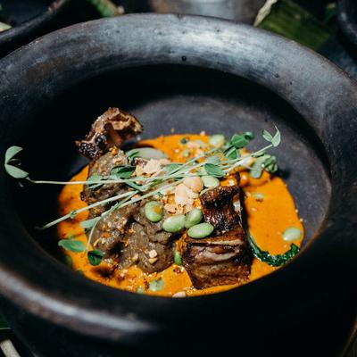 Tender beef in orange sauce topped with nuts and microgreens.