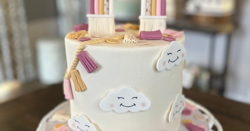 Cake decorated with smiling clouds and tassels