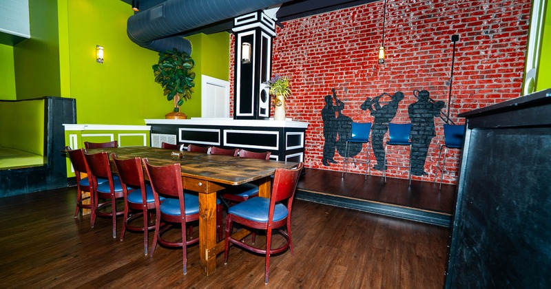 Dining area with wooden table, red chairs, and a brick wall with musician silhouettes