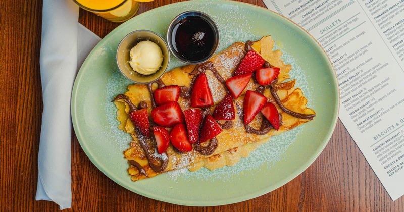 Crepes with strawberries and Nutella, served with syrup and butter