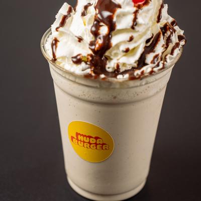 Chocolate Chip Cookie Milkshake topped with whipped cream and a chocolate drzzle.