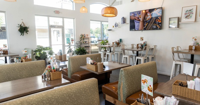 Casual dining restaurant with booths, woven pendant lights and natural light from large windows.