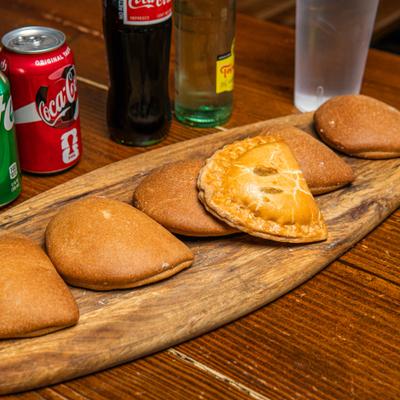 Pan de Calabasi pastries served on a wooden tray, alongside drinks.