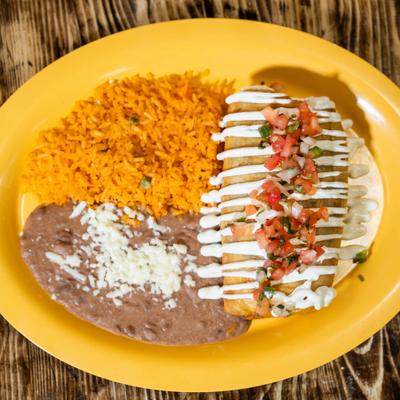 Crispy chimichanga topped with sour cream, tomato salsa, rice, and beans.