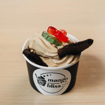 Frozen yogurt topped with cookies and gummy candy.