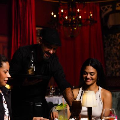 Server placing drinks on the table for guests during the dinner service.