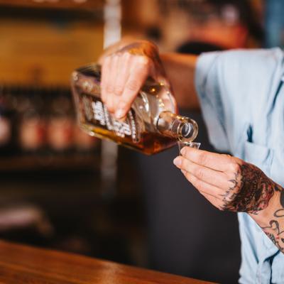 Hands pouring whiskey.