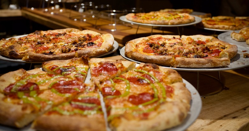 Assorted pizza stands on a counter