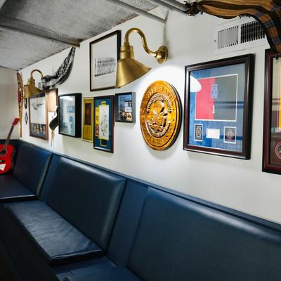 A room with blue upholstered seating by a wall with various decorative items.
