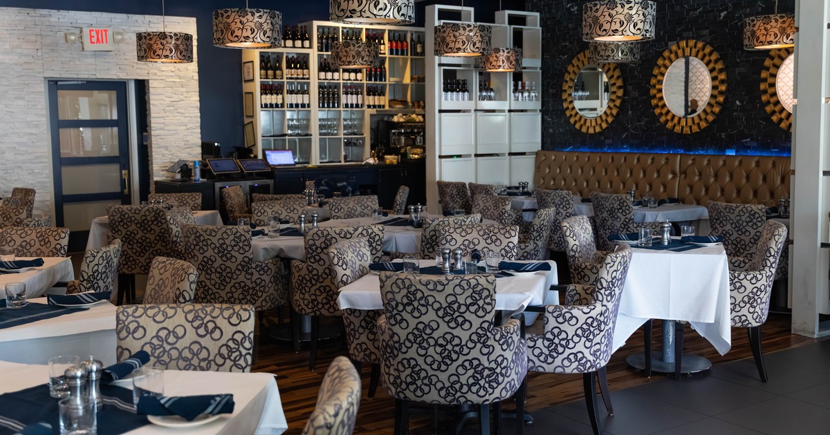 A modern interior - white tablecloths, patterned chairs and pendant lights.