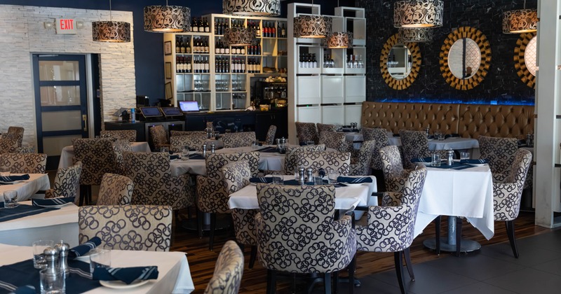 A modern interior - white tablecloths, patterned chairs and pendant lights.
