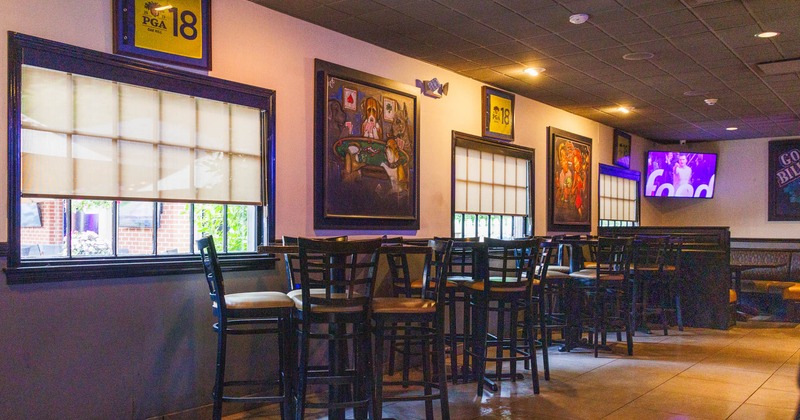 Interior seating area with high-top tables and framed art