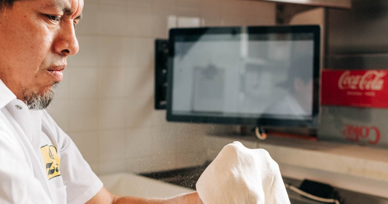 Pizza chef stretching pizza dough