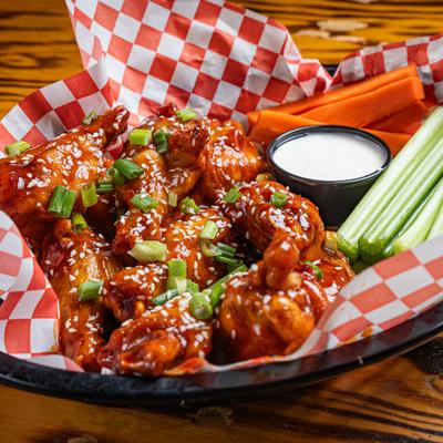 Angry Korean Wings served with carrot and celery sticks and a dip.