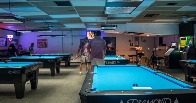 Pool tables and guys playing