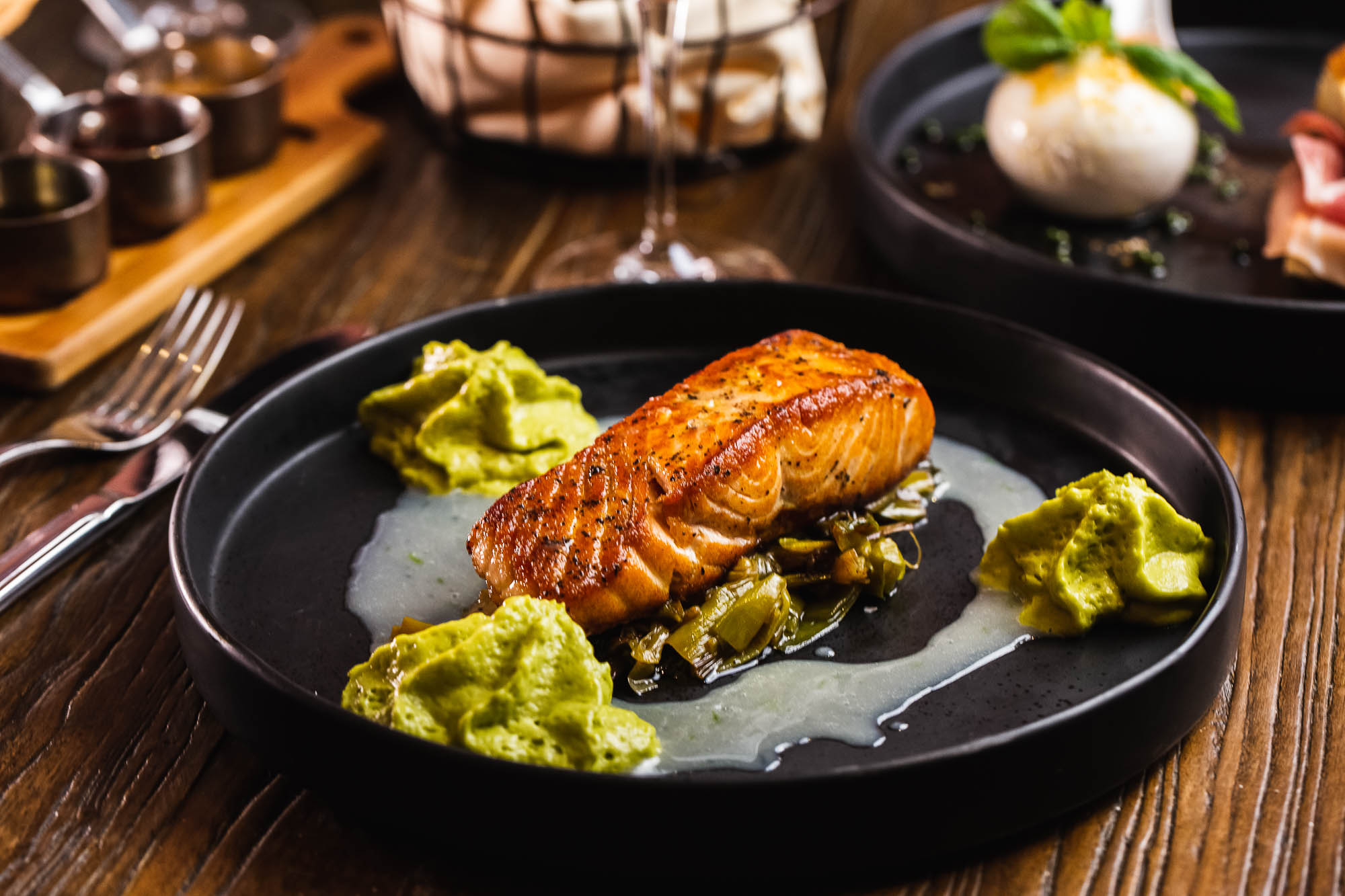 Salmon with grilled leeks, coconut, lime sauce, and spicy avocado mousse