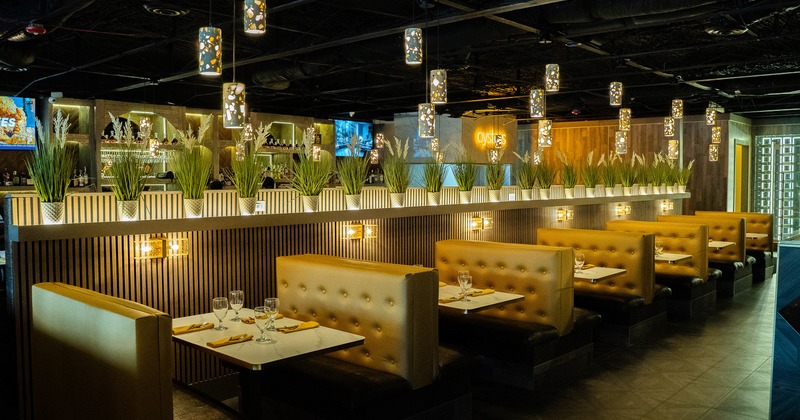 Interior of modern and cozy dining area with upholstered dining booths set for guests