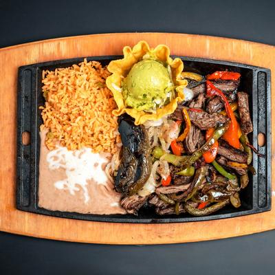 Fajitas with beef, rice, beans, and guacamole.