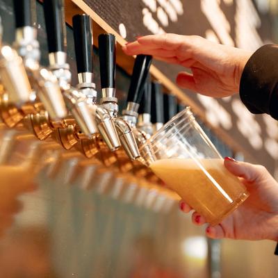 Beer dispensaries, hands filling up a cup.