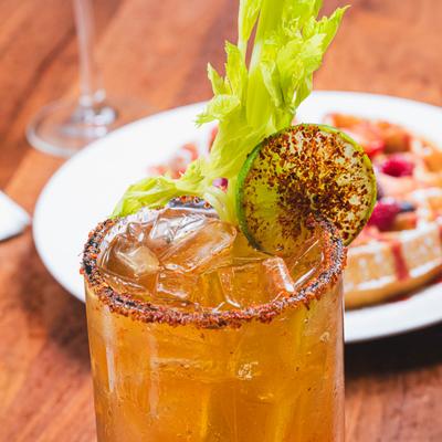 Michelada cocktail with a waffle in the background, close up.