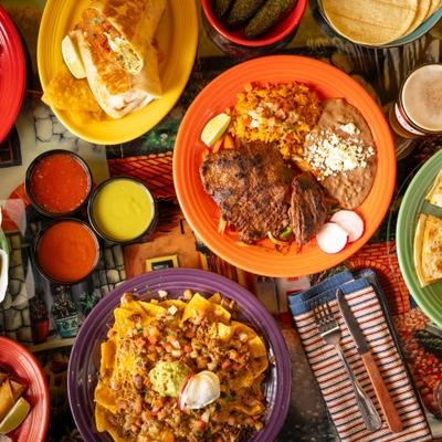 Assorted Mexican dishes on colorful plates.